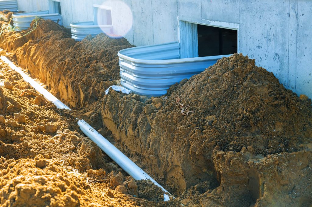 Plastic piping and a rainpipe against and around the a drainpipe in ground house