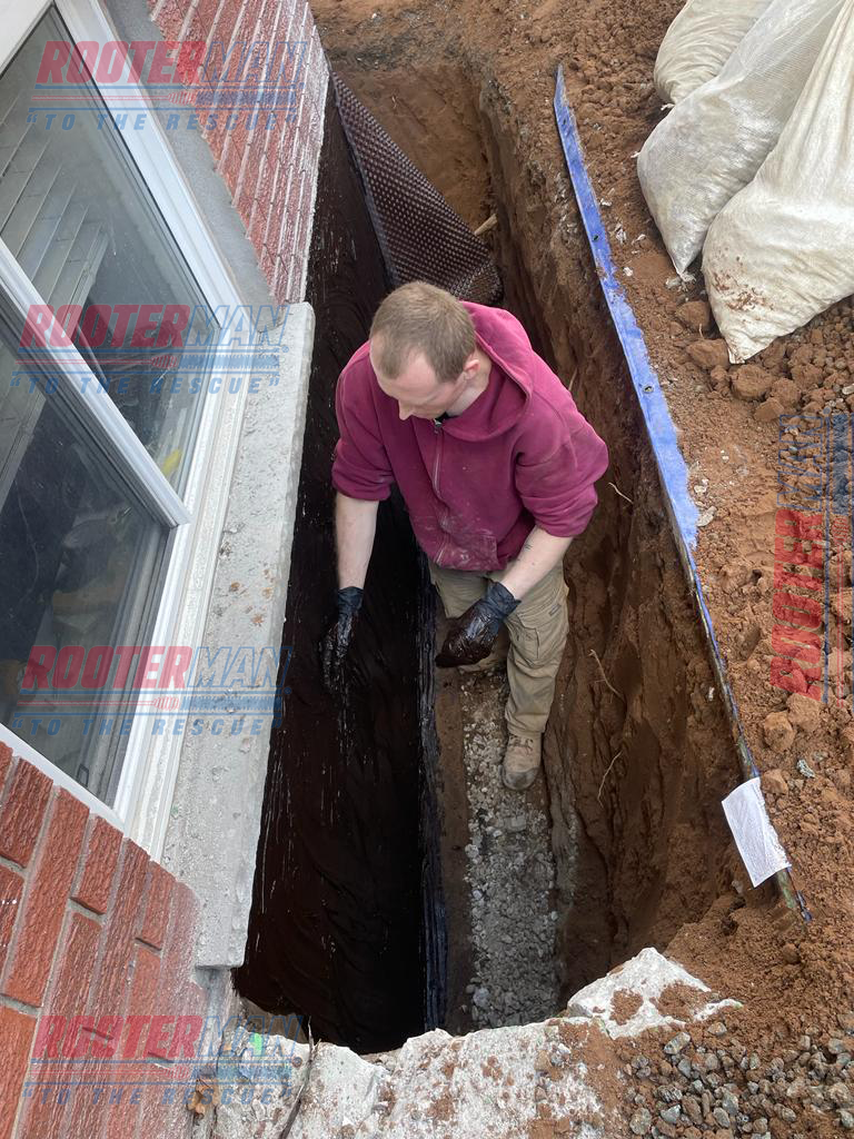 Waterproofing technician applying waterproofing sealant